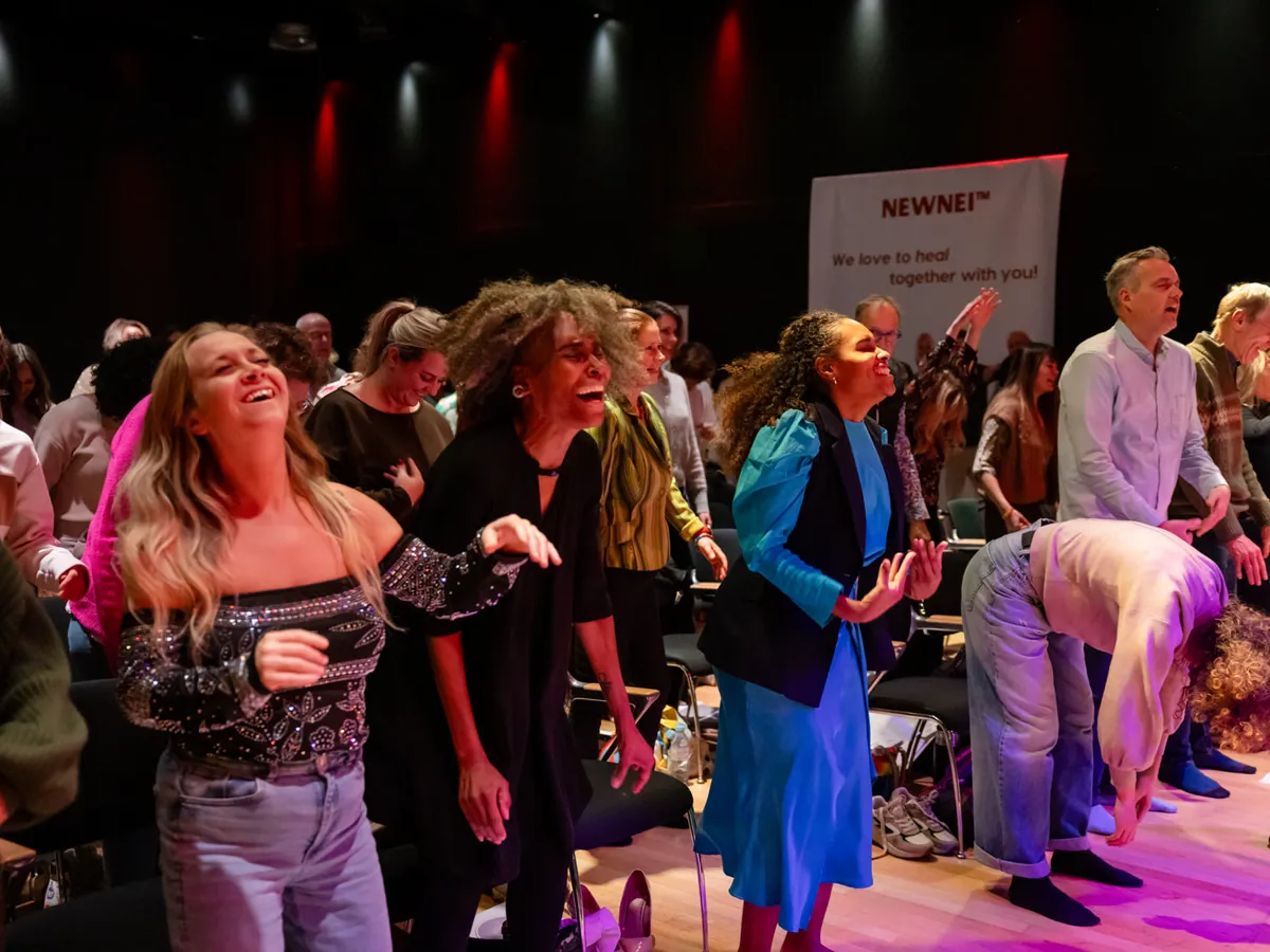 Lachende en dansende deelnemers in de zaal